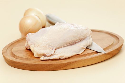 Fresh chicken breast photographed on a wooden cutting board.