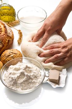 female hands in flour closeup kneading dough on table 