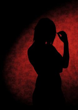 Girl silhouettes on the stool on red background