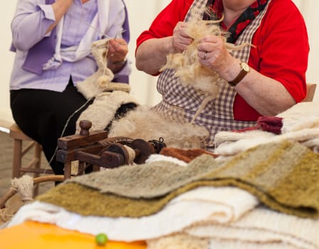 Photo of a elderly woman that spinning wool