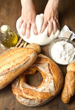 female hands in flour closeup kneading dough on table 