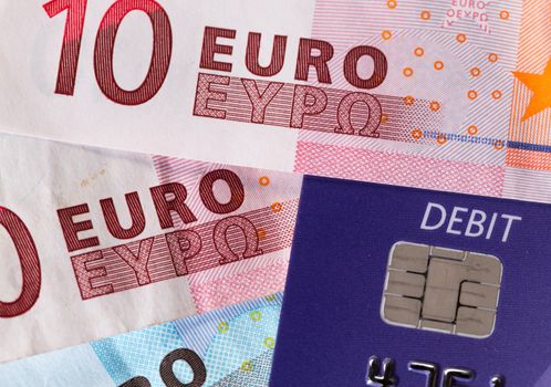 Debit word on plastic card on euro note suggesting debt problems in Europe