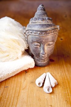 Luxury bath or shower set with towel, sponge and buddha and shells on wooden table