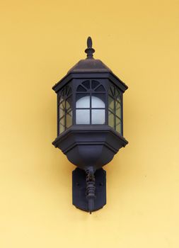 Vintage street lamp on yellow wall 