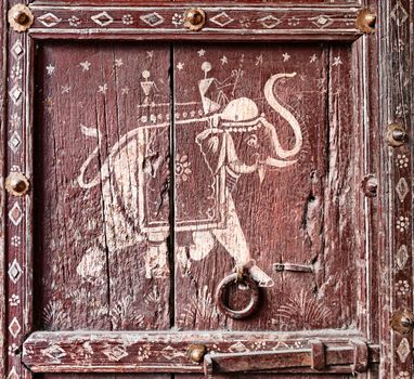 Old wooden door with a picture of an elephant. Fragment. Rajasthan, India