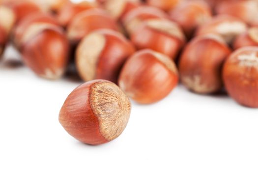 Closeup view of hazelnuts over white background