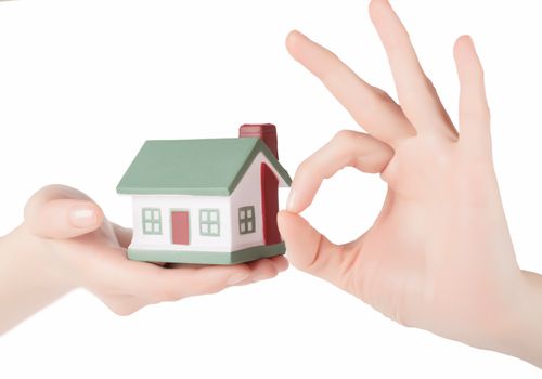 Little house toy in woman hands isolated over white background