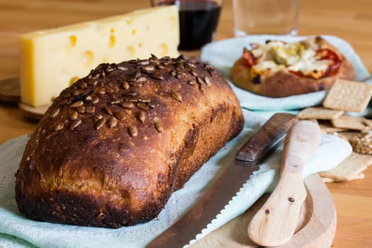 Composition with crusty bread, yellow cheese and red wine