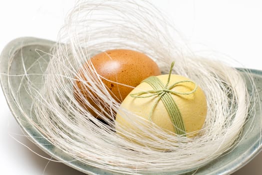 Easter eggs in a white nest on a plate