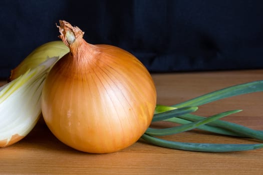 Onion with fresh green sprout on wooden table