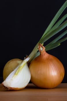 Onion with fresh green sprout on wooden table
