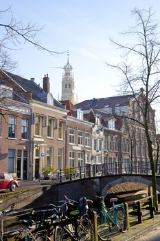 Dutch canal with old houses, church and bridge with blue sky