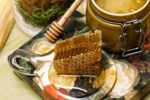 Sweet honey in pot with honeycomb and wooden stick