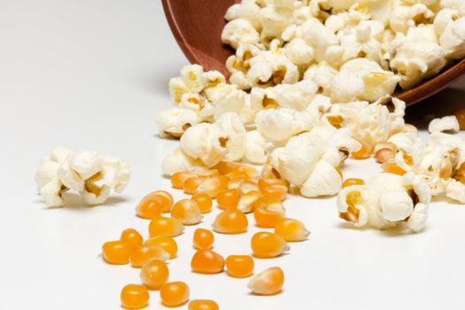 Popcorn and corn seeds rolling from a fallen bowl