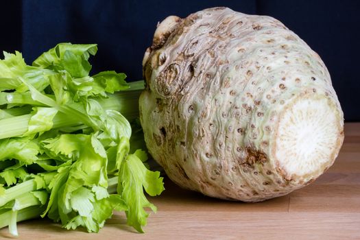 Fresh celery root with it's leafs on wooden table