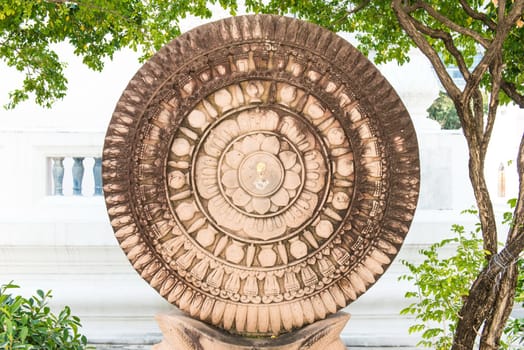 Close up of a wheel of Buddha made from lime stone, taken on a sunny day