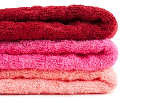 Stack of bright red and pink towels over white background