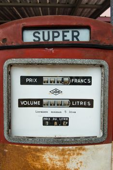 A vintage antique Gasoline fuel pump on red background