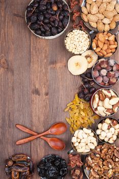 Frame of variety of fruits and nuts on a dark wooden surface