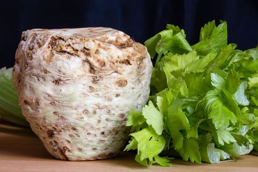 Fresh celery root with it's leafs on wooden table