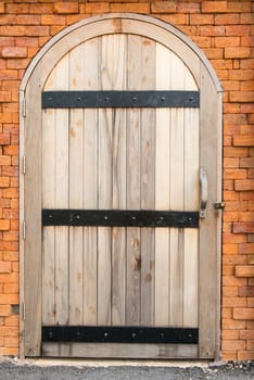 Vintage old wooden door on a red brick wall, taken outdoor