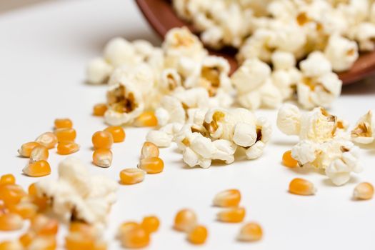 Popcorn and corn seeds rolling from a fallen bowl