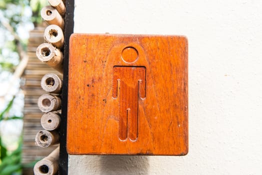 Brown hard wood polished toilet sign, taken outdoor on a sunny day