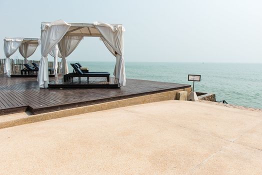 Beach front dual leather relax chairs inside a tent facing the sea, taken on a sunny day