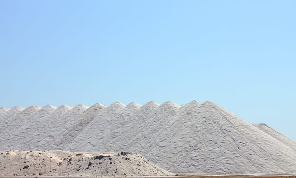 Extraction of salt. Salt mountains on blue sky.