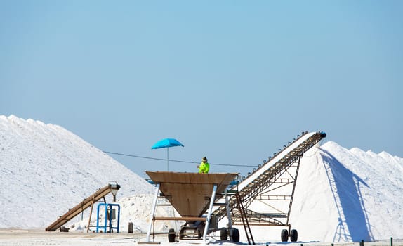 Extraction of salt. Salt mountains on blue sky.