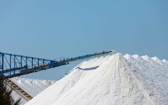 Extraction of salt. Salt mountains on blue sky.