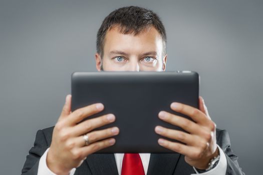 An image of a handsome business man reading his tablet pc