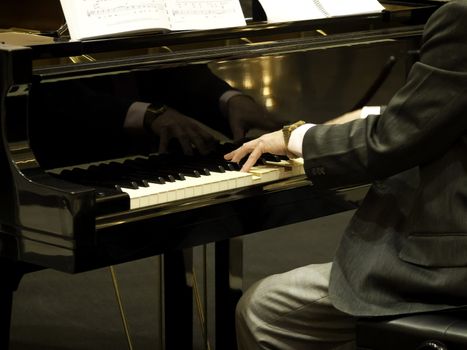 Close up of male hands playing piano.
