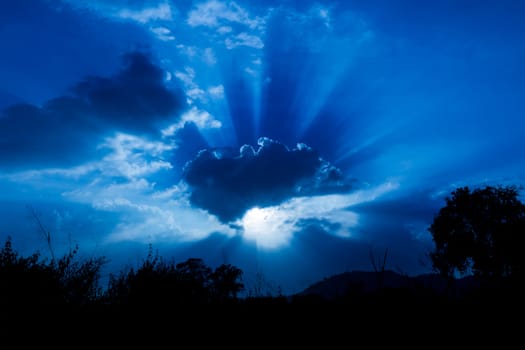 Rays of sun shining through the clouds at sunset
