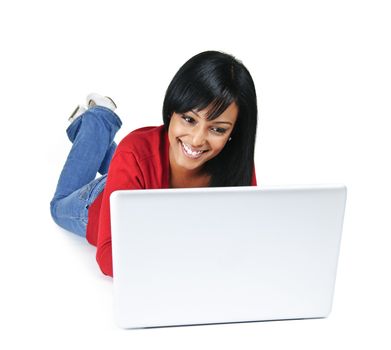 Smiling black woman typing on computer laying on floor