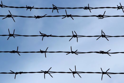 Barb wire fence and blue sky blackground