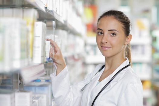 Portrait of a young female pharmacist selecting a medication
