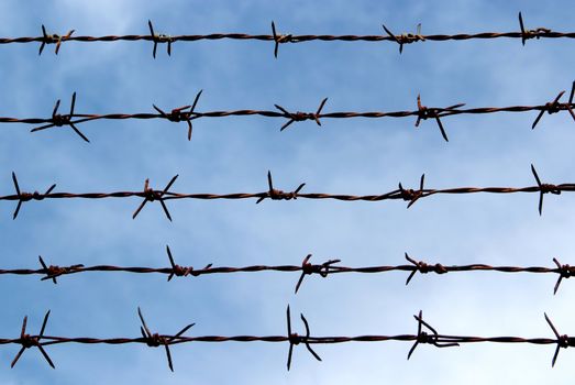 Barb wire fence and blue sky blackground