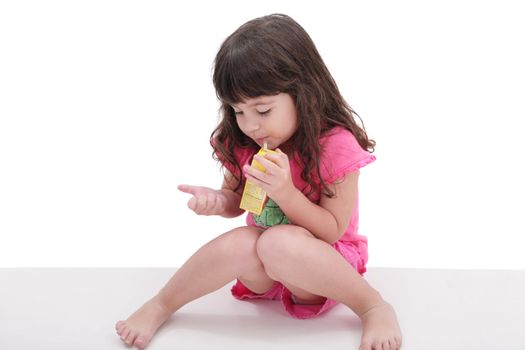 Close-up of beautiful little girl drinking from a juice box. Shot in studio over white.