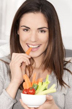 smiling woman on sofa eating vegetable salad