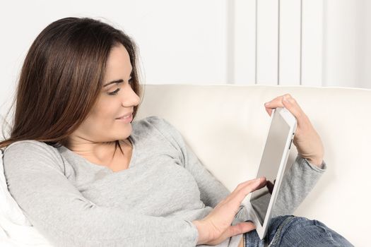 Beautiful woman with tablet on sofa at home