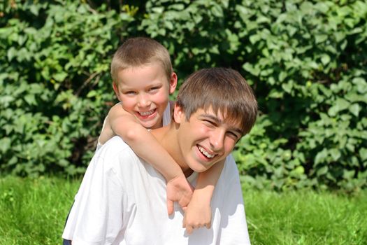 Happy Older and Little Brothers Portrait in the Summer Park
