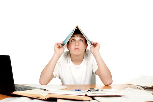 Student at the school desk with many books cover his head with exercise book