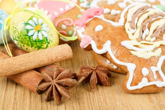Easter gingerbreads and painted egg on wooden background