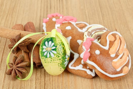 Easter gingerbreads and painted egg on wooden background