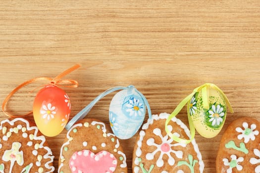 Easter gingerbreads and painted egg on wooden background