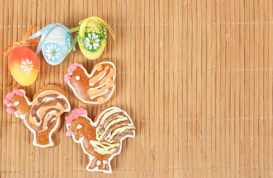 Easter gingerbreads and painted egg on wooden background