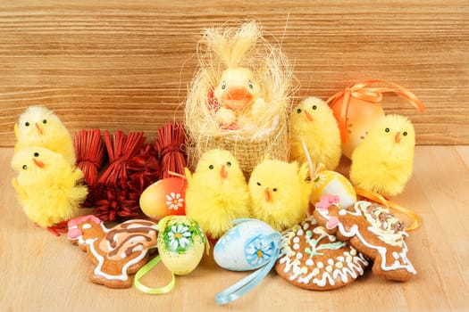 easter decoration, gingerbread, chicken and painted eggs wooden background