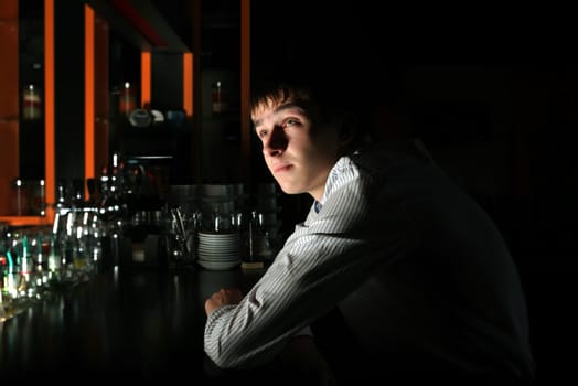 Young Man Sitting in the Darkness at the Bar