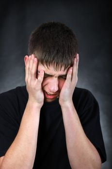 Portrait of Painful Young Man on the Black Background